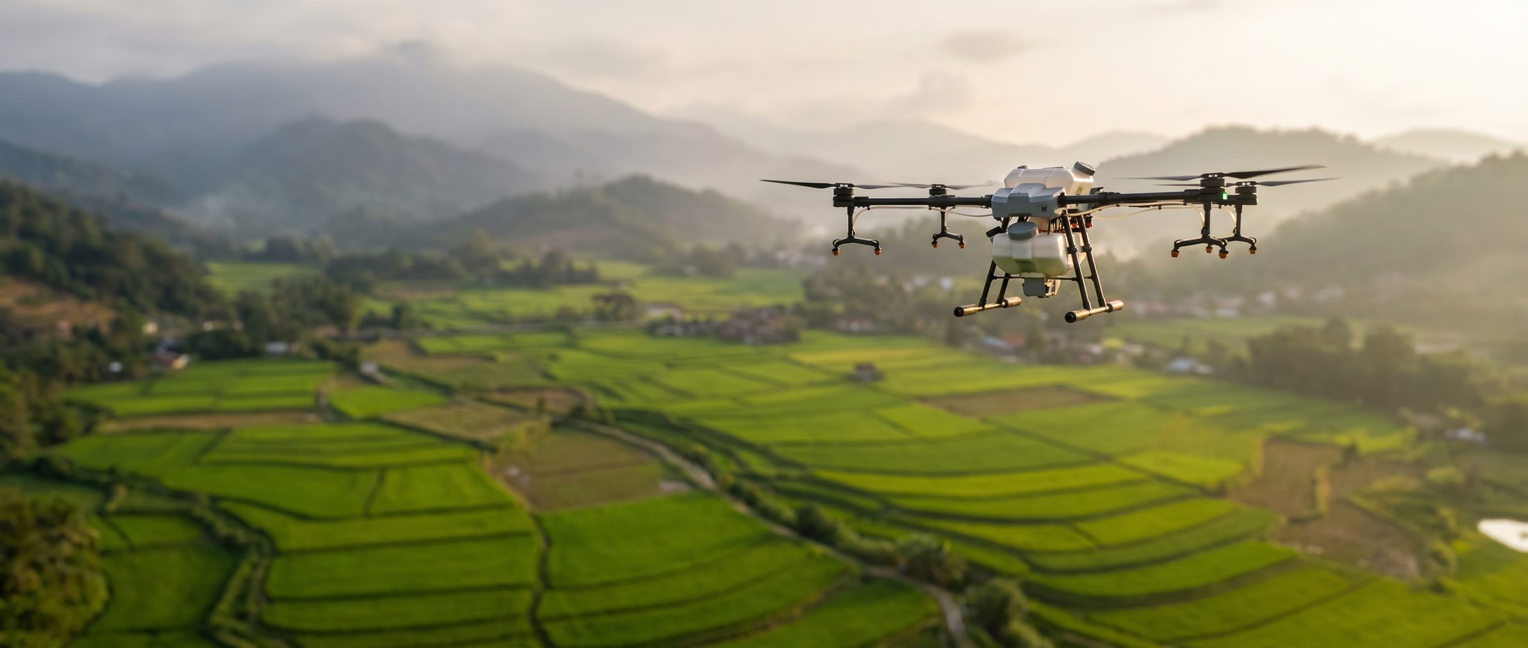 Drone X agriculture spraying drone in flight over green terraced farmland with misty mountains in the background