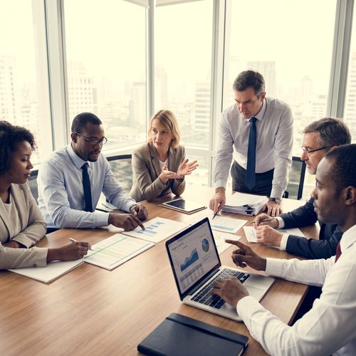 Business people in a meeting discussing documents and a laptop